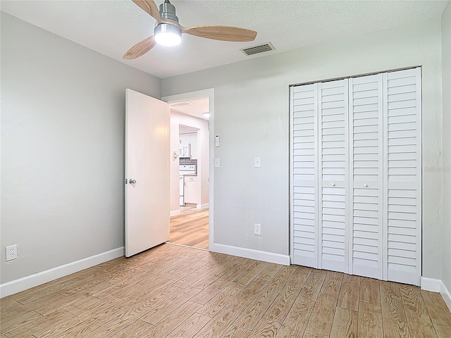 809 Sugar House Blvd, Port Orange, FL 32129 - unfurnished bedroom with light wood-type flooring, a closet, ceiling fan, and a textured ceiling