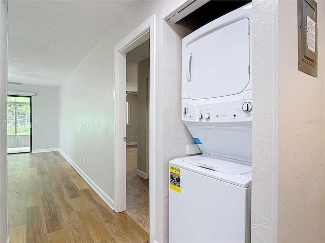 809 Sugar House Blvd, Port Orange, FL 32129 - laundry room with stacked washing machine and dryer, wood finished floors, and a textured ceiling