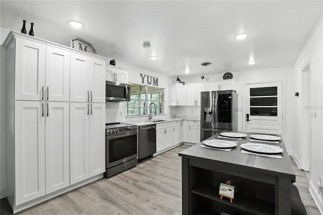 2908 Clear Way, Orlando, FL 32805 - kitchen with stainless steel appliances, light wood-style flooring, white cabinetry, light countertops, and recessed lighting
