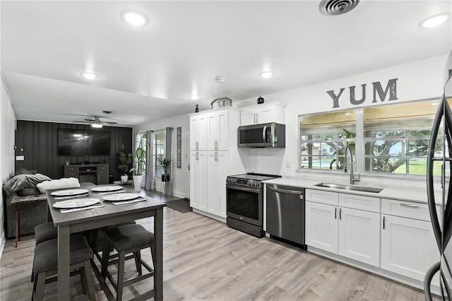 2908 Clear Way, Orlando, FL 32805 - kitchen featuring appliances with stainless steel finishes, ceiling fan, light wood finished floors, and recessed lighting