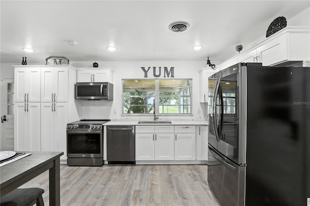 2908 Clear Way, Orlando, FL 32805 - kitchen featuring appliances with stainless steel finishes, light wood-type flooring, and white cabinets