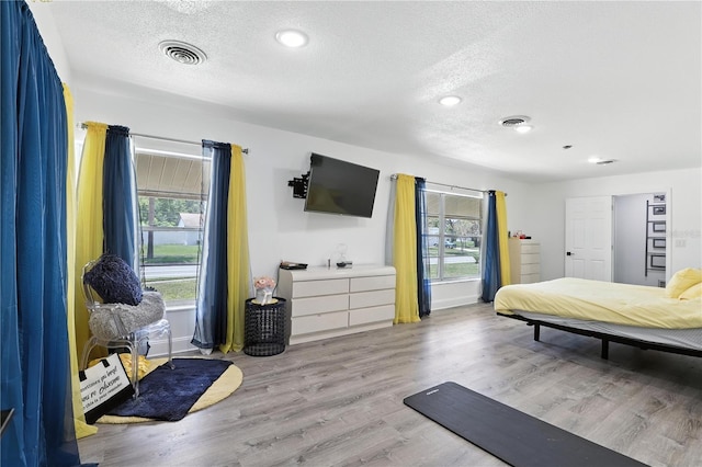 2908 Clear Way, Orlando, FL 32805 - bedroom featuring a textured ceiling, multiple windows, wood finished floors, and recessed lighting