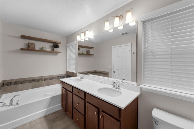 8968 Hildreth Ave, Orlando, FL 32832 - full bathroom with double vanity, a garden tub, tile patterned flooring, and a textured ceiling