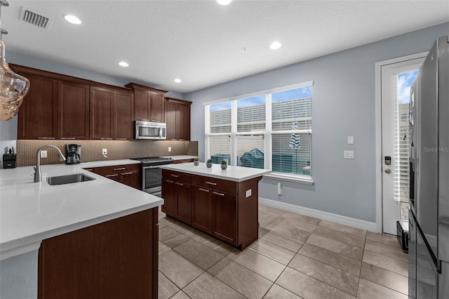 8968 Hildreth Ave, Orlando, FL 32832 - kitchen with stainless steel appliances, backsplash, light countertops, a center island, and recessed lighting