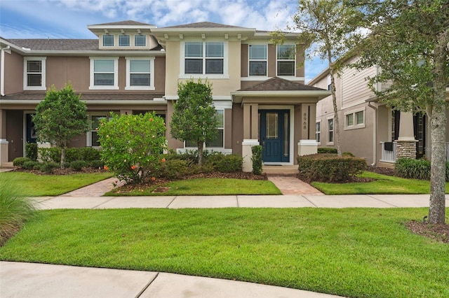 8968 Hildreth Ave, Orlando, FL 32832 - view of front of property with stucco siding, a front yard, and a shingled roof