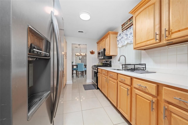 1105 Arrowsmith Ave, Orlando, FL 32809 - kitchen featuring stainless steel appliances, backsplash, light countertops, light tile patterned floors, and light brown cabinets