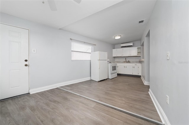 1105 Arrowsmith Ave, Orlando, FL 32809 - kitchen with white appliances, a wall mounted AC, open shelves, white cabinets, and light wood-style floors