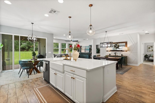 31924 Geoff, Sorrento, FL 32776 - kitchen featuring dishwasher, light wood-style flooring, light countertops, a kitchen island with sink, and pendant lighting