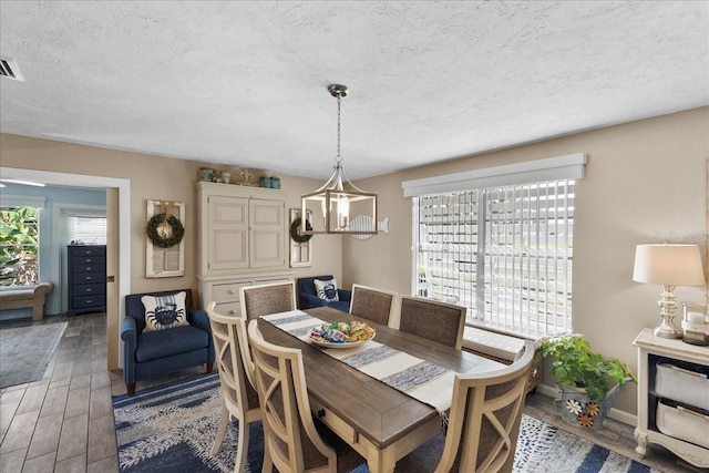 2356 Date Palm Dr, Edgewater, FL 32141 - dining room featuring healthy amount of natural light, light wood-style flooring, a textured ceiling, and a chandelier