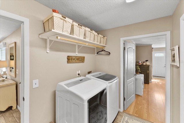 2356 Date Palm Dr, Edgewater, FL 32141 - washroom with washer and clothes dryer, light wood finished floors, plenty of natural light, and a textured ceiling