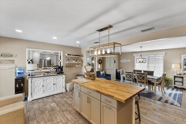 2356 Date Palm Dr, Edgewater, FL 32141 - kitchen featuring wooden counters, light wood-style flooring, a breakfast bar, pendant lighting, and a kitchen island
