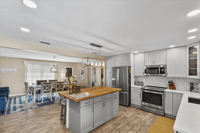 2356 Date Palm Dr, Edgewater, FL 32141 - kitchen with appliances with stainless steel finishes, butcher block countertops, light wood finished floors, gray cabinetry, and recessed lighting