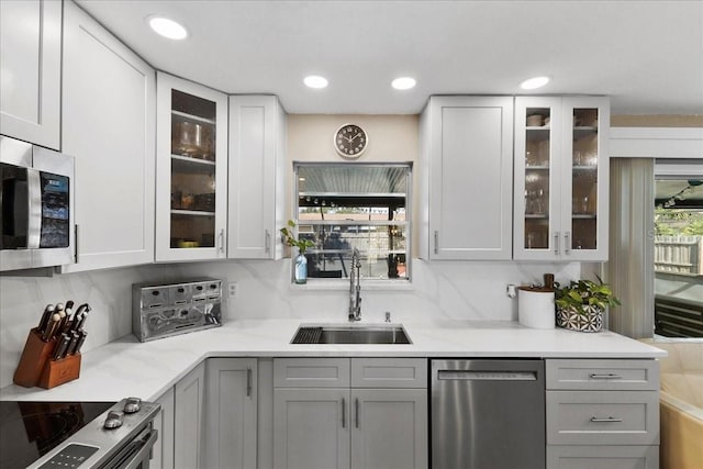 2356 Date Palm Dr, Edgewater, FL 32141 - kitchen featuring appliances with stainless steel finishes, gray cabinets, glass insert cabinets, decorative backsplash, and recessed lighting