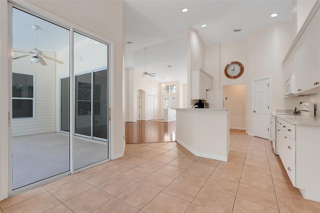 20542 Queen Alexandra Dr, Leesburg, FL 34748 - kitchen featuring a ceiling fan, white appliances, light tile patterned flooring, a high ceiling, and recessed lighting