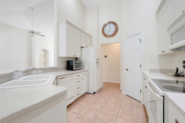 20542 Queen Alexandra Dr, Leesburg, FL 34748 - kitchen with white appliances, a high ceiling, a ceiling fan, light countertops, and white cabinetry