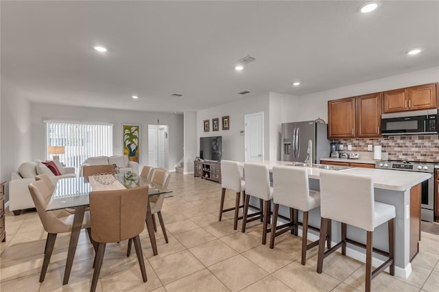 1866 Red Canyon Dr, Kissimmee, FL 34744 - kitchen featuring stainless steel appliances, open floor plan, a kitchen island with sink, decorative backsplash, and recessed lighting