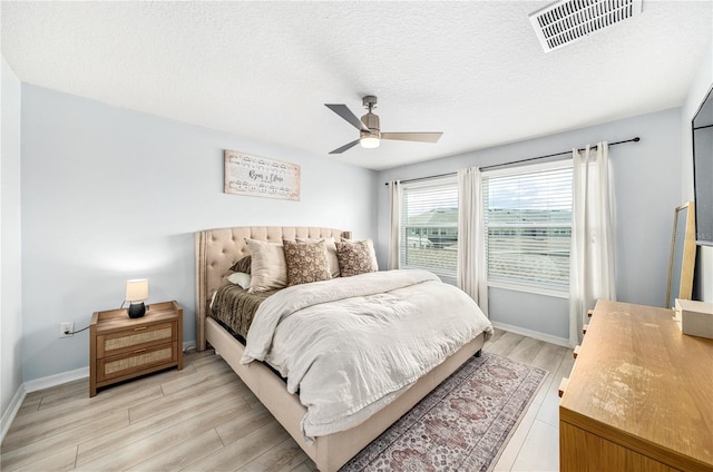 8164 Wood Sage Dr, Winter Garden, FL 34787 - bedroom with light wood-style flooring, a ceiling fan, and a textured ceiling