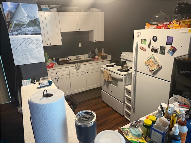 4035 Nimons St, Orlando, FL 32811 - kitchen with white appliances, light countertops, white cabinetry, and dark wood finished floors
