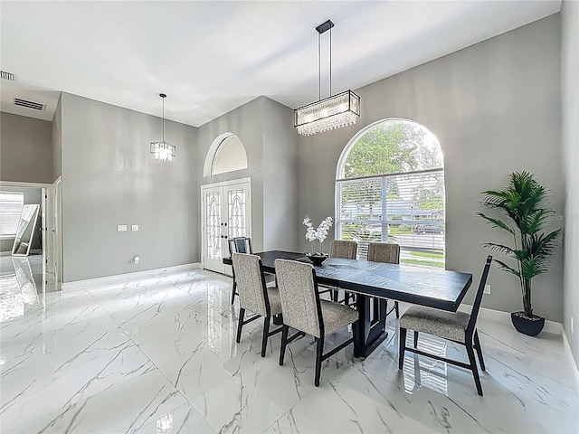 704 Forest View Ct, Winter Springs, FL 32708 - dining space featuring a chandelier, light marble finish flooring, a high ceiling, and french doors