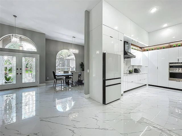 704 Forest View Ct, Winter Springs, FL 32708 - kitchen featuring wall chimney exhaust hood, freestanding refrigerator, double oven, white cabinets, and french doors