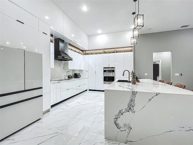 704 Forest View Ct, Winter Springs, FL 32708 - kitchen featuring wall chimney range hood, modern cabinets, stainless steel double oven, white cabinets, and light countertops