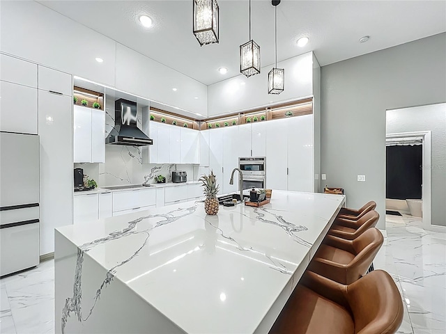704 Forest View Ct, Winter Springs, FL 32708 - kitchen with wall chimney range hood, light marble finish floors, modern cabinets, white cabinets, and a spacious island