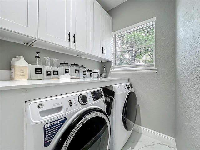 704 Forest View Ct, Winter Springs, FL 32708 - laundry room with cabinet space, washing machine and clothes dryer, marble finish floors, and a textured wall