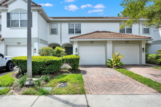 6931 Sperone St, Orlando, FL 32819 - multi unit property featuring decorative driveway, stucco siding, a garage, and a tile roof