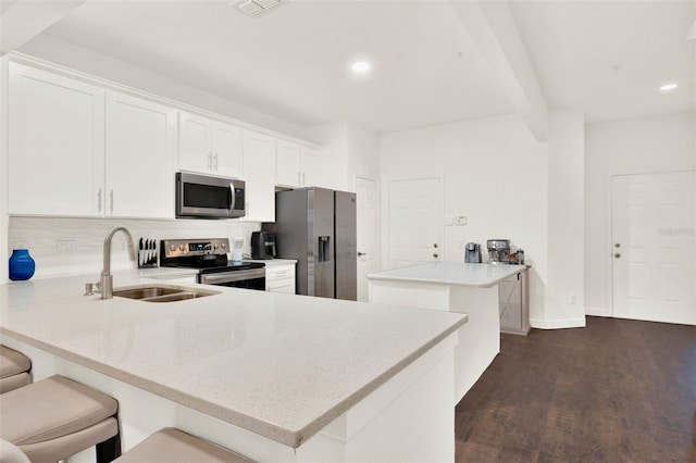 6931 Sperone St, Orlando, FL 32819 - kitchen featuring appliances with stainless steel finishes, backsplash, a peninsula, dark wood finished floors, and recessed lighting