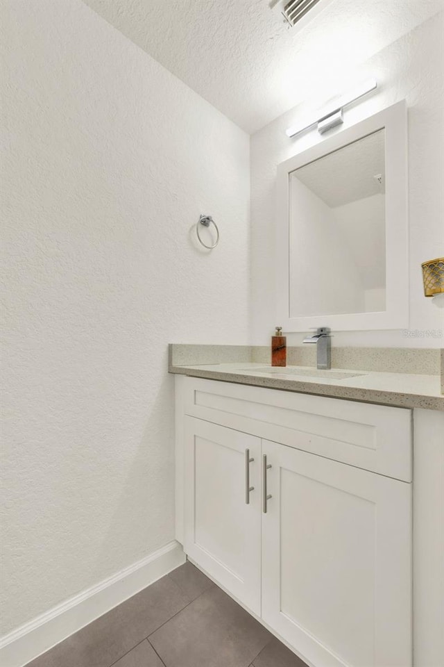 6931 Sperone St, Orlando, FL 32819 - bathroom featuring vanity, tile patterned flooring, a textured wall, and a textured ceiling