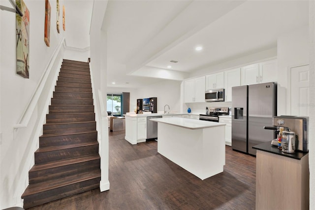6931 Sperone St, Orlando, FL 32819 - kitchen with appliances with stainless steel finishes, a peninsula, dark wood-type flooring, white cabinetry, and recessed lighting