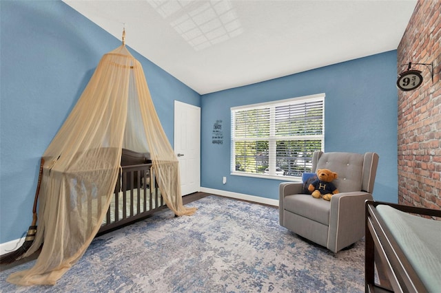 6931 Sperone St, Orlando, FL 32819 - bedroom with wood finished floors, brick wall, and a crib