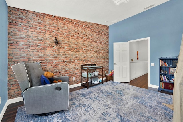 6931 Sperone St, Orlando, FL 32819 - living area featuring wood finished floors, a high ceiling, and brick wall