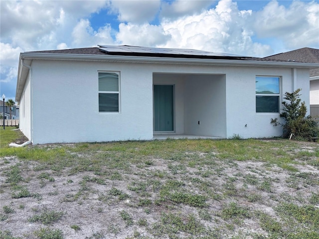6300 Chirpine Ln, Saint Cloud, FL 34771 - rear view of house featuring stucco siding and roof mounted solar panels