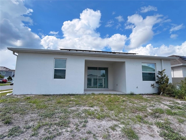 6300 Chirpine Ln, Saint Cloud, FL 34771 - back of property featuring stucco siding, solar panels, and a patio area