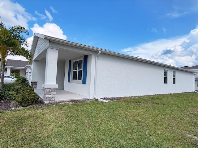 6300 Chirpine Ln, Saint Cloud, FL 34771 - view of side of property with stucco siding, a lawn, and covered porch