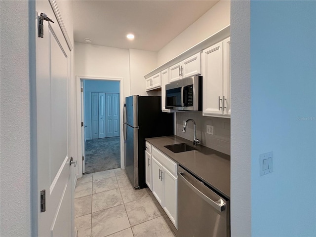 6300 Chirpine Ln, Saint Cloud, FL 34771 - kitchen featuring stainless steel appliances, dark countertops, white cabinetry, light tile patterned flooring, and light colored carpet