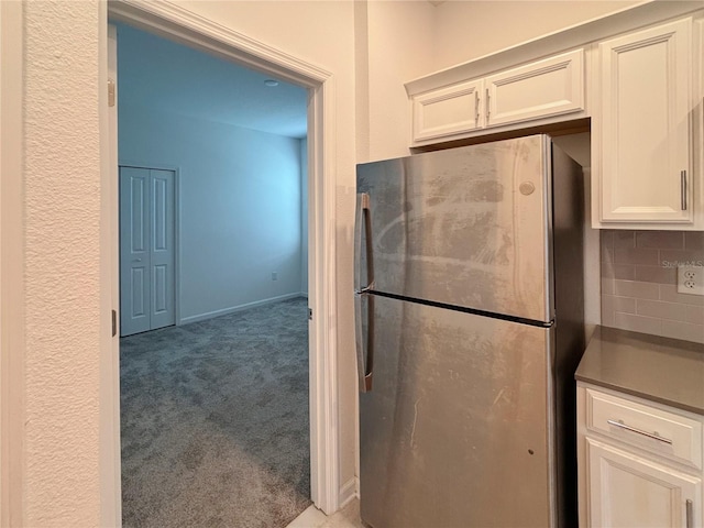 6300 Chirpine Ln, Saint Cloud, FL 34771 - kitchen featuring freestanding refrigerator, light colored carpet, decorative backsplash, and white cabinets