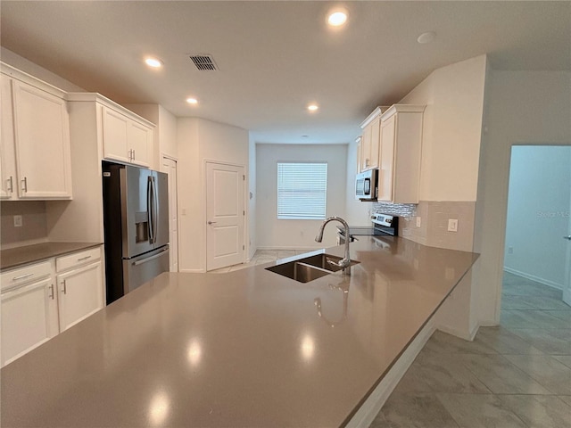 6300 Chirpine Ln, Saint Cloud, FL 34771 - kitchen featuring appliances with stainless steel finishes, white cabinets, recessed lighting, decorative backsplash, and dark countertops