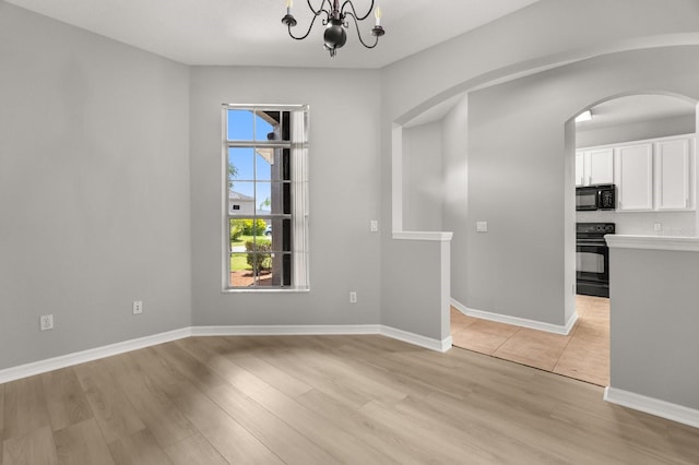 13658 Hidden Forest Cir, Orlando, FL 32828 - unfurnished room featuring a chandelier, light wood-type flooring, and arched walkways