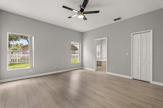 13658 Hidden Forest Cir, Orlando, FL 32828 - unfurnished bedroom featuring multiple windows, light wood-type flooring, ensuite bathroom, and ceiling fan