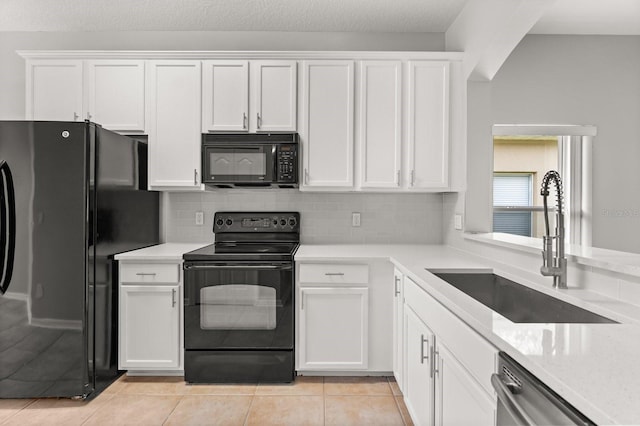 13658 Hidden Forest Cir, Orlando, FL 32828 - kitchen featuring black appliances, white cabinets, light tile patterned floors, and decorative backsplash