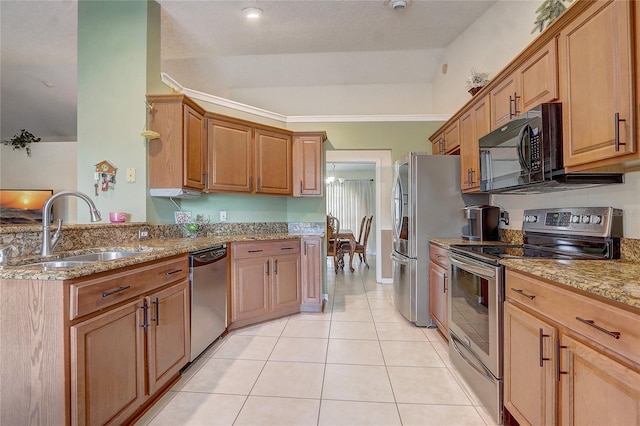 2800 Woodsmere Ct, Kissimmee, FL 34746 - kitchen with stainless steel appliances, light stone countertops, light tile patterned floors, a peninsula, and brown cabinets