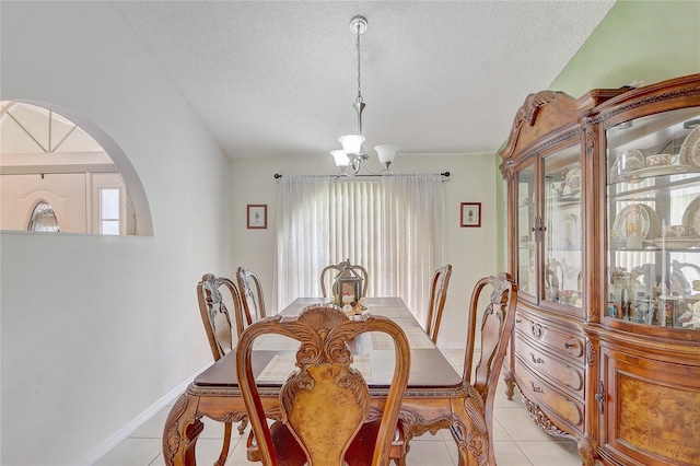 2800 Woodsmere Ct, Kissimmee, FL 34746 - dining space with a chandelier, light tile patterned floors, a textured ceiling, vaulted ceiling, and arched walkways