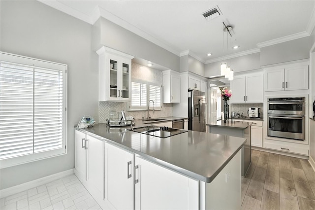 1769 Turnberry Ter, Orlando, FL 32804 - kitchen with stainless steel appliances, crown molding, tasteful backsplash, glass insert cabinets, and white cabinets