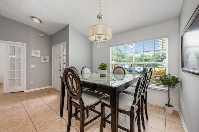 14301 Bending Branch Ct, Orlando, FL 32824 - dining room featuring a textured ceiling, light tile patterned floors, and a chandelier