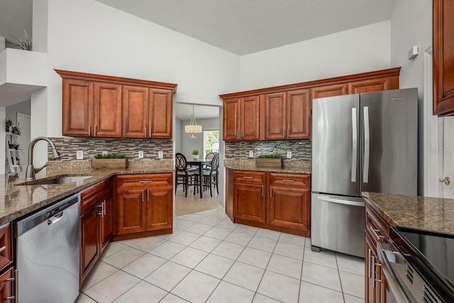 14301 Bending Branch Ct, Orlando, FL 32824 - kitchen featuring appliances with stainless steel finishes, backsplash, dark stone counters, light tile patterned floors, and brown cabinets