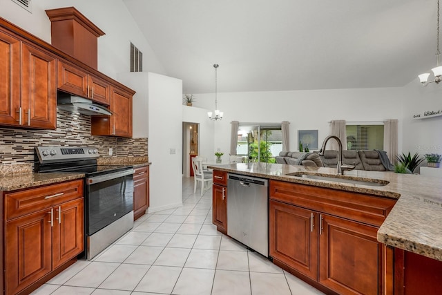 14301 Bending Branch Ct, Orlando, FL 32824 - kitchen featuring appliances with stainless steel finishes, a chandelier, under cabinet range hood, tasteful backsplash, and hanging light fixtures