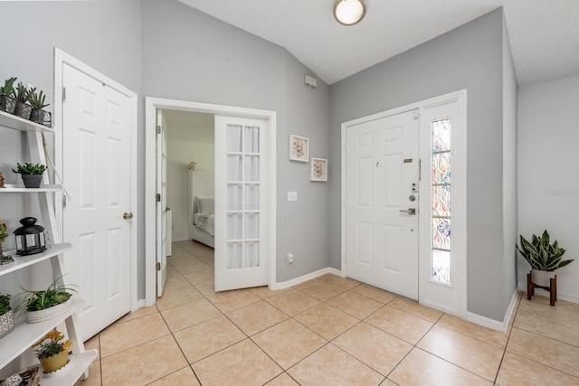14301 Bending Branch Ct, Orlando, FL 32824 - entryway with light tile patterned floors and vaulted ceiling