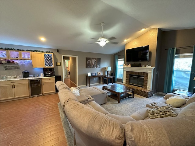 1140 Odoniel Loop S, Lakeland, FL 33809 - living area with wine cooler, wet bar, light wood-style floors, a fireplace, and ceiling fan